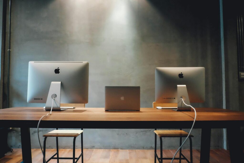 pexels-photo-265125-265125 Minimalist office space with dual monitors on a wooden table, promoting a contemporary work environment.